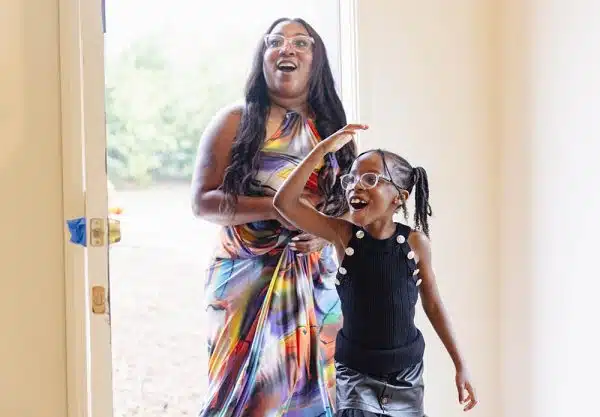 Mom and daughter walking in their new home for the first time